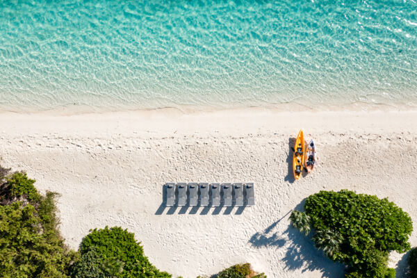 Overhead aerial view of loungers and kayaks on a beach