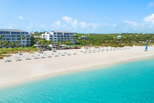 Luxury resort on a clean white-sand beach with turquoise water.